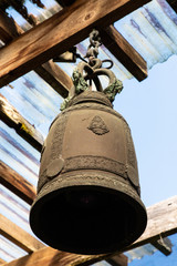 Large rusty Tibetan bell hangs from the gazebo ceiling