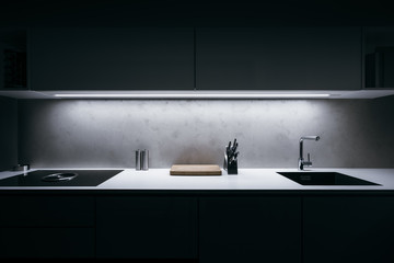 Modern kitchen in minimalist design during night with LED light strip and premium materials such as...