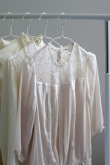 Collection of white shirts and blouses on a clothing rack. Selective focus.