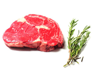 Raw uncooked fresh rib eye beef steak and rosemary on white background isolated.