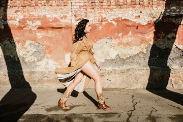Gender equality, Women’s Day, march 8, Girl power, feminism concept. A woman in trench coat walks on spring day street