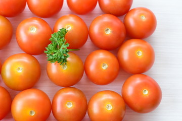 Fresh cherry tomato, displayed in containers on white wooden background