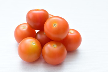 Fresh cherry tomato, displayed in containers on white wooden background