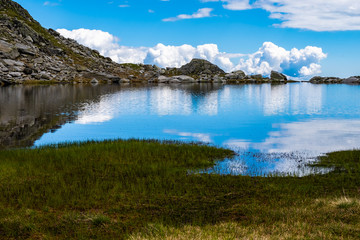 MOUNTAINS AND CLOUDS REFLECTED ON LAKE