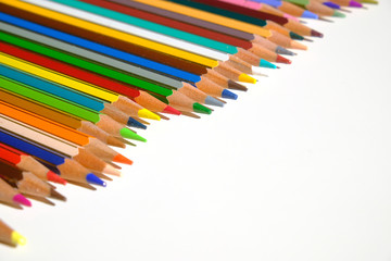 Crayons - colored pencil set arranged on white background