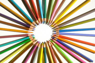 Set of colored pencils arranged in a circle on a white background