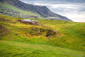 Wonderful icelandic nature landscape. View from the top. High mountains, mountain river and green grassland. Green meadows. Iceland.