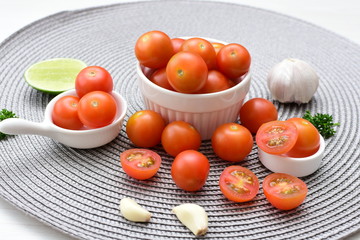 Fresh cherry tomato, displayed in containers, on cloth background