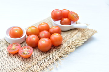 Fresh cherry tomato, displayed in containers, on cloth background