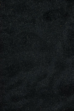 Black sand floor texture from above. Background.