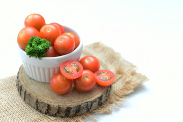 Fresh cherry tomato, displayed in containers, on cloth background