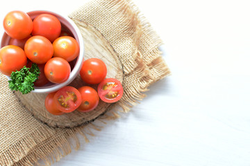Fresh cherry tomato, displayed in containers, on cloth background
