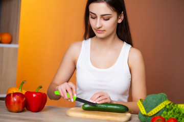 Obraz na płótnie Canvas Young beautiful girl prepares a useful diet salad