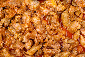 Stewed pork pieces with onions in tomato sauce with paprika. Texture