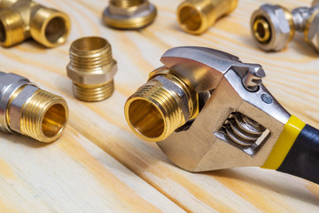 Plumbing fitting and adjustable spanner on wooden boards during repair or replacement of spare parts