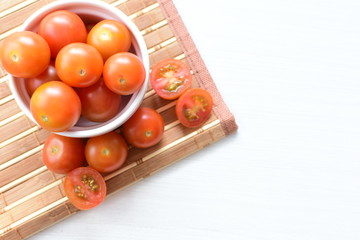 Fresh cherry tomato, displayed in containers on wooden background