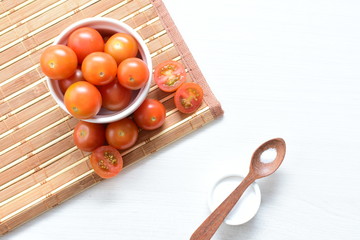 Fresh cherry tomato, displayed in containers on wooden background