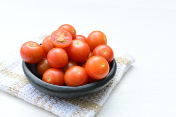 Fresh cherry tomato, displayed in containers, on cloth background