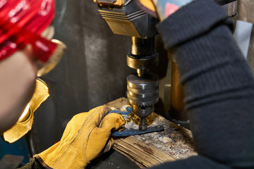 female artisan works on a drilling machine with a countersink close-up