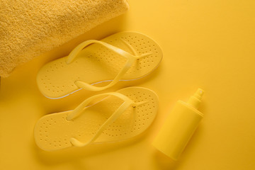Towel, sandals and sunscreen spray
