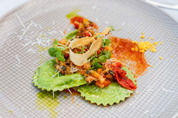 Closeup on green spinach ravioli with vegetables on plate