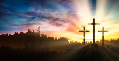three crosses on the rock at sunset