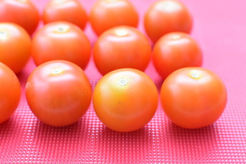 Fresh cherry tomato, displayed in containers on colorful colors background
