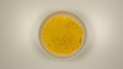 TOP VIEW: Curcuma powder in a white dish