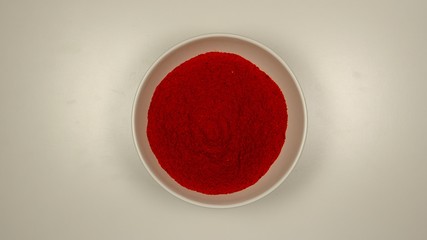 TOP VIEW: Red pepper powder in a white dish