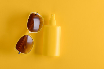 Obraz na płótnie Canvas Sunscreen spray and sunglasses