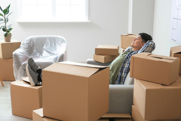 Asian man relaxing at home on moving day