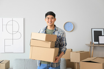 Asian man with belongings at home on moving day