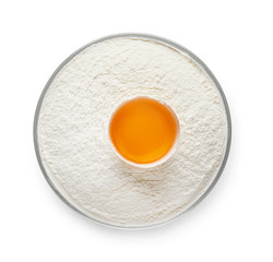 Raw chicken egg and flour in bowl on white background