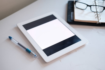 top view of digital tablet and notepad on yellow background 