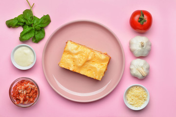 Tasty lasagna with ingredients on color background