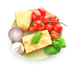 Plate with ingredients for lasagna on white background