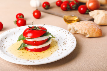 Mozzarella cheese with tomatoes, basil and oil on plate