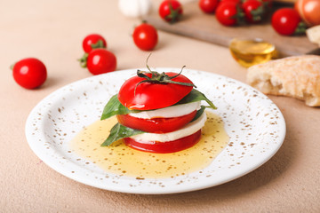 Mozzarella cheese with tomatoes, basil and oil on plate