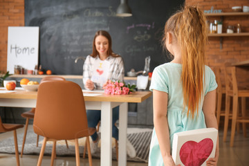 Little daughter greeting her mother in kitchen