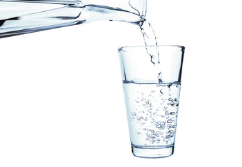 Pouring of fresh water in glass on white background