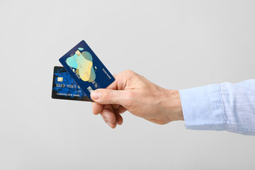 Male hand with credit cards on grey background