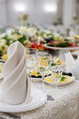 Vertical images of elegant dinner table setting in restaurant or hotel with wine glasses. Luxurious elegant dinner at the table. Holiday table decoration