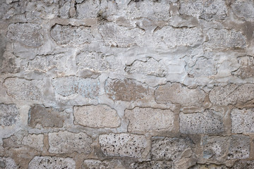 Old ragged brick wall painted white, background. White brick wall texture