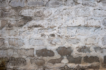 Old bumpy brick wall painted white, backdrop. Weathered stonewall texture