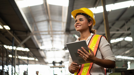 Portrait of industrial worker standing with tablet holding in her hand feeling proud and confident looking for the new opportunity, new challenge, concept manufacturing industry, Professional worker.