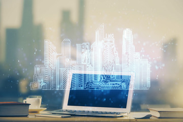 Desktop computer background in office and big town buildings hologram drawing. Double exposure. Smart city concept.