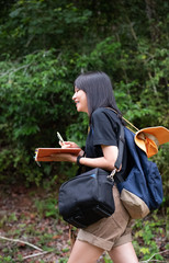 Obraz premium The beautiful woman backpack and holdking book in hand,walking in a park,relax time,on holiday