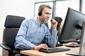 Caucasian man call center is working with intend to help his customer. Hot line operator support,...