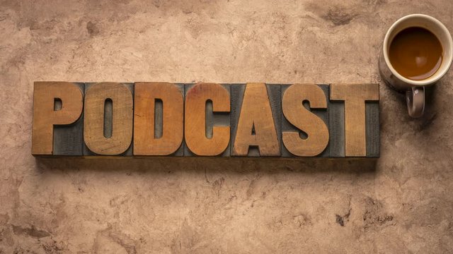 Podcast word, internet communication, media and broadcast concept - stop motion animation with vintage letterpress wood type blocks and coffee against handmade bark paper.