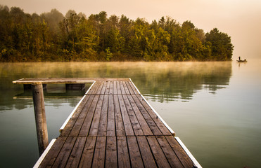 Fototapeta na wymiar Misty morning pier at the lake